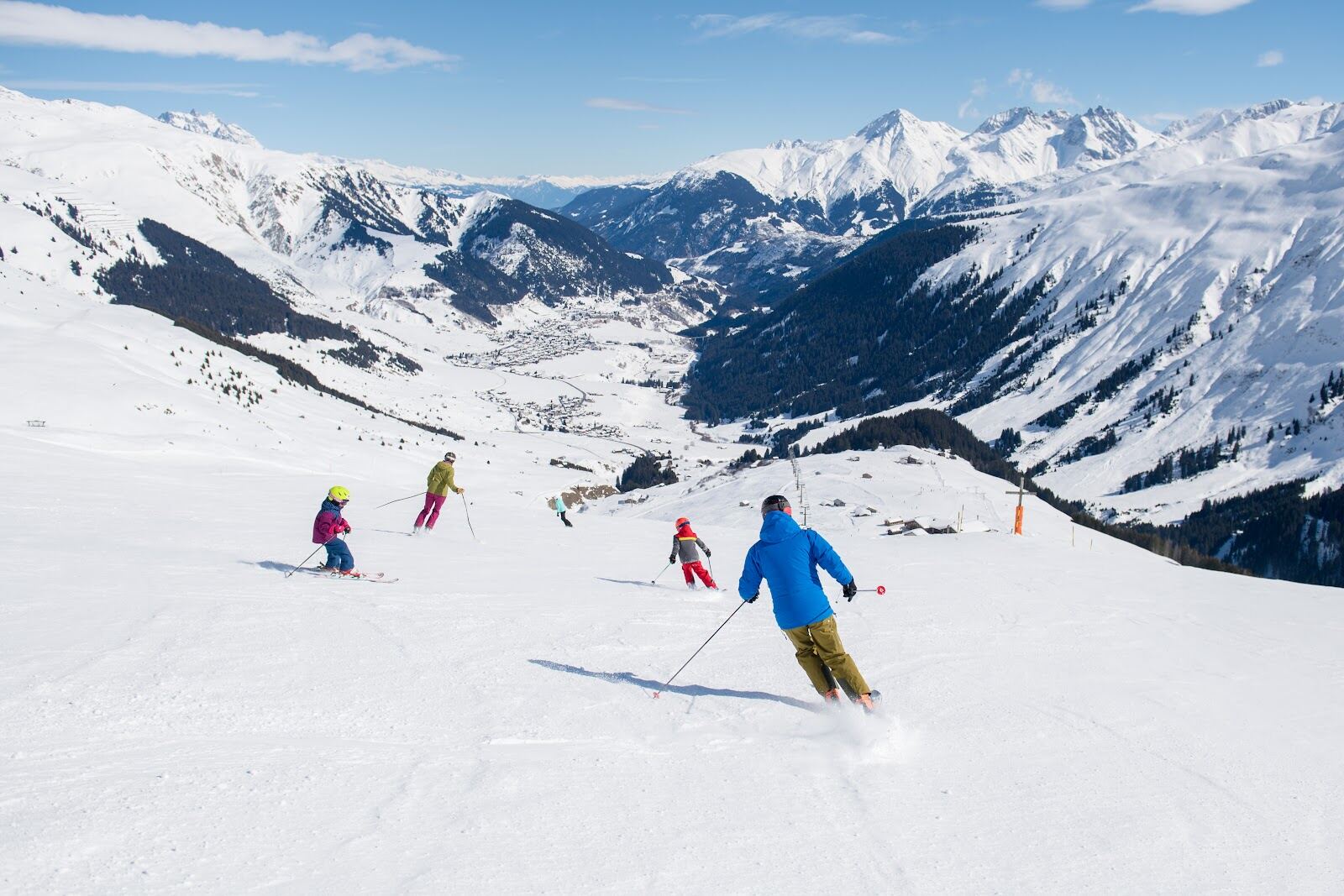 Long red pistes dropping toward the Disentis valley