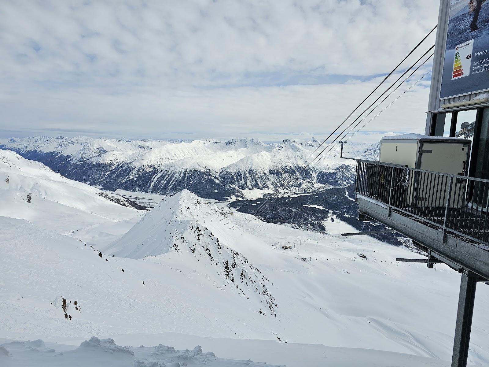 Skiers on a wide sunny groomed run above St Moritz