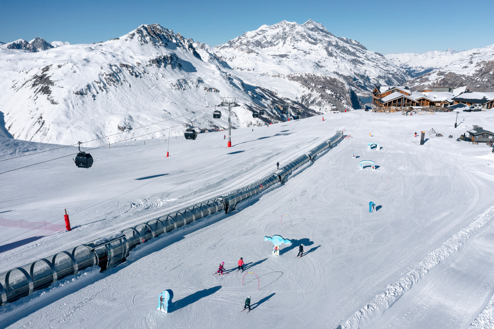 Skiers on a wide groomed run in the Espace Killy above Val d'Isere